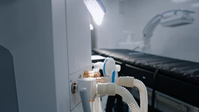 Close up of advanced equipment for surgery in operating room of modern hospital. Tubes of life support or general anesthesia machine standing in bright operating block in clinic or medical facility.