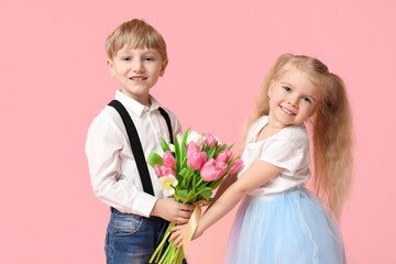 Cute little children with bouquet of beautiful tulips on pink background. International Women's Day