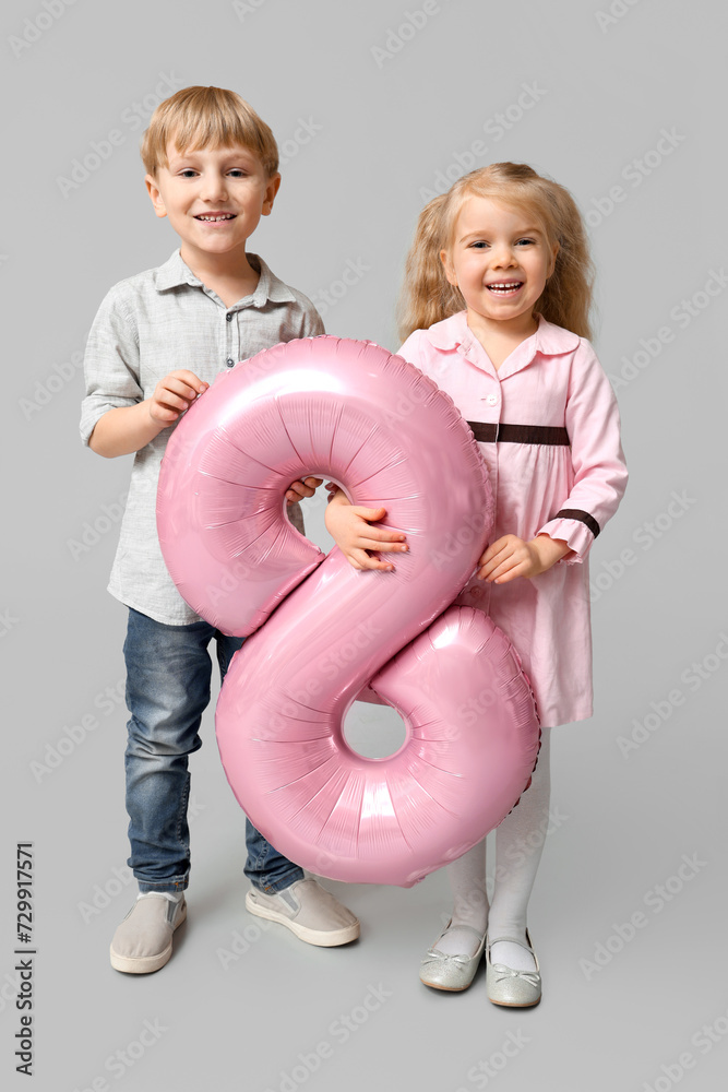 Wall mural cute little children with pink air balloon in shape of figure 8 on grey background. international wo