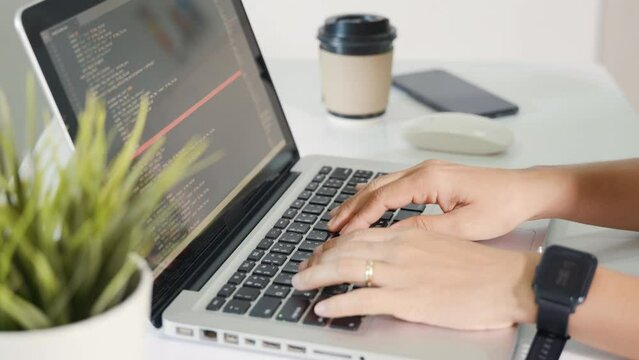 Programmer woman writing program HTML code sitting at workplace in office, IT software developer hands typing data coding programming with laptop computer, IT start up concept, Web application design