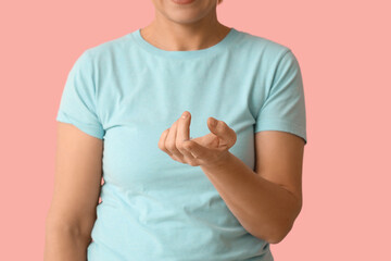 Mature woman with contact lens on pink background