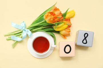 Cube calendar with date 08, bouquet of beautiful tulips and cup of tea on yellow background. International Women's Day