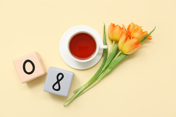 Cube calendar with date 08, beautiful tulips and cup of tea on yellow background. International Women's Day