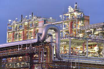 chemical factory at night with buildings, pipelines and lighting - industrial plant