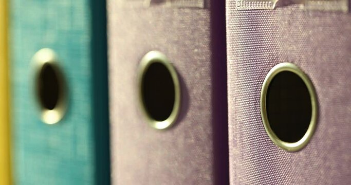 Multicolored folders with files on shelf