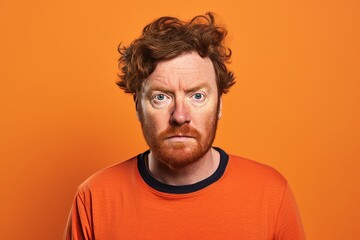Portrait of a funny man with red hair on a orange background