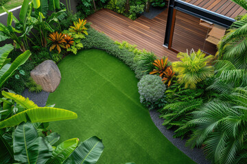 high view of a contemporary Australian home or residential buildings front yard features artificial grass lawn turf, timber edging and many tropical plants - obrazy, fototapety, plakaty