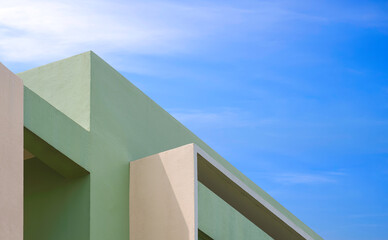 Modern green and beige house building with geometric pattern of shading fins concrete on exterior wall against blue sky, Low angle and perspective side view, Abstract minimal architecture background