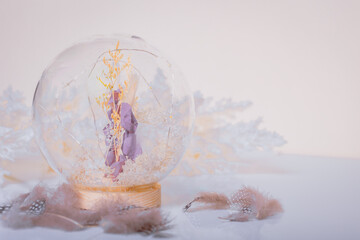 A boho flower encased in a glass sphere against a light backdrop amidst bohemian decor.