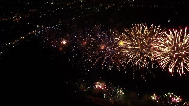 Bird's eye view of fireworks over the city of Dnepr, Ukraine. Colored lights in the sky over a river in Europe. Pixel texture. pyrotechnics show. Aerial shot. Festive fireworks.