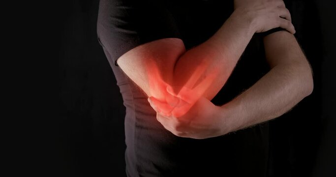 Man holding painful elbow with red glow indicating joint pain. Concept of inflammation, injury, or arthritis.