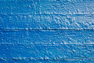 The old wooden surface is painted with blue oil paint. Close-up. Texture. Abstract background