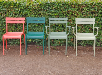 Four Colorful plastic chairs in the park - 729940550
