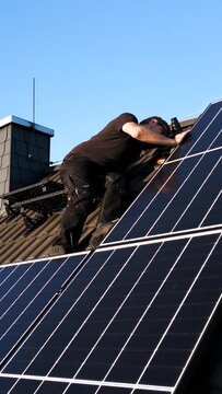 Technician Checking Solar Panels on the Roof of a House