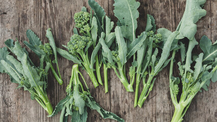 Young broccoli inflorescences on a wooden background. Top view.