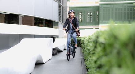 Eco friendly, businesswoman ride bicycle outside to reduce carbon footprint. Environmental...
