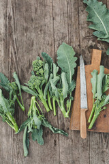 Freshly cut bunches of broccoli with stems on a grey wooden table.