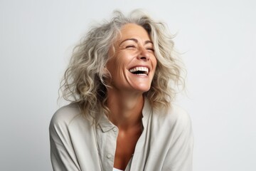 Obraz na płótnie Canvas Portrait of a happy senior woman laughing on a gray background.