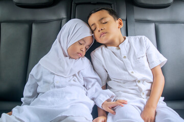Muslim sibling children sleeping peacefully in the back seat in the car on the trip