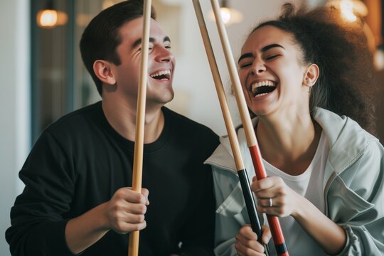 two people laughing and holding pool sticks