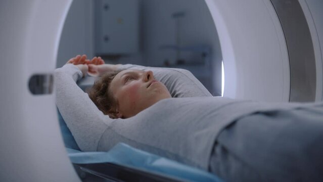 Close up shot of patient lying on CT, PET, or MRI machine bed. Advanced tools scan body and brain for detailed examination in medical facility. High-tech modern medical laboratory. Healthcare concept.