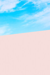 Serene pastel sky with pink and blue hues transitioning to a peach surface for a dreamy background