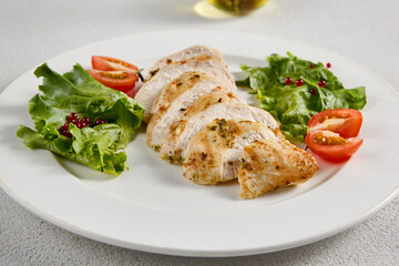 Grilled chicken breast with vibrant salad garnish on a minimalistic white setup, perfect for clean eating and diet concepts