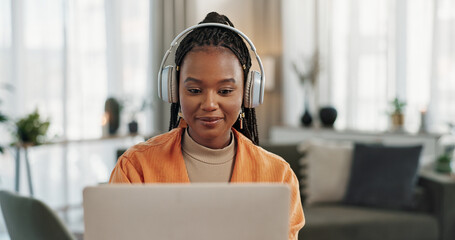 Laptop, headphones and young woman in living room listening to music, playlist or album in modern apartment. Technology, smile and young African person streaming song on computer in lounge at home.