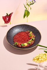Beef Tartare with Gazpacho Sauce amidst Pastel Tones and Surreal Spring or Summer Flowers