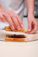 woman folding a sandwich with jam close-up of hands