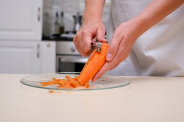 female cook peeling carrots hands close-up