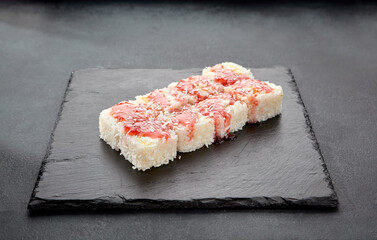 Sweet roll with coconut and strawberry topping; a dessert sushi combining tropical flavors with a fruity finish