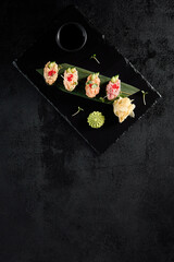 Elegant spicy sushi assortment with salmon, shrimp, tuna, and eel, top view on dark slate