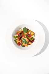 Top view of a Mediterranean salad with octopus, potatoes, tomatoes, and Kalamata olives with a spicy sauce