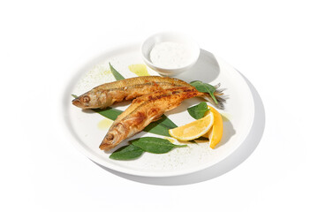 Grilled vendace fish with lemon and sour cream on a white plate, ideal for culinary presentations and food marketing