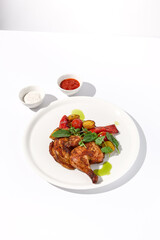 Grilled chicken tabaka with roasted potatoes and sauces, served on an isolated white background, perfect for restaurant menus