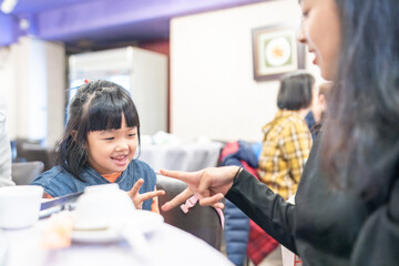 Naklejka premium 台湾台北市の中華料理レストランにいる台湾人の小さな女の子の子供と家族 Children and family of a small Taiwanese girl at a Chinese restaurant in Taipei, Taiwan