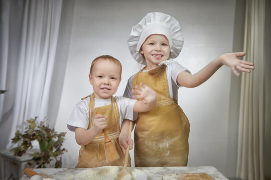 Cute oriental family with small brother and sister cooking in kitchen on Ramadan, Kurban-Bairam, Eid al-Adha. Funny children boy and girl at cook photo shoot. Pancakes, Maslenitsa, Easter