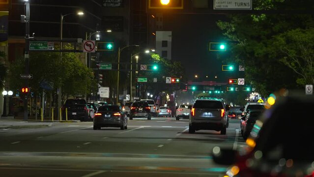 Urban road intersection with traffic lights and moving cars at night in american city. Transportation system in USA