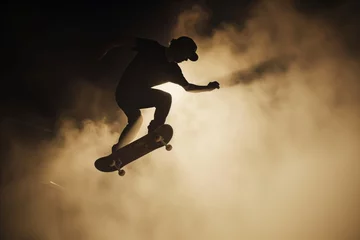 Küchenrückwand glas motiv backlit figure of skateboarder in dusty air, midjump © studioworkstock
