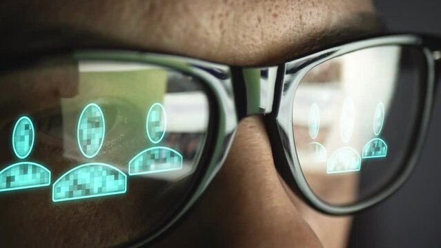 Cg footage is a double reflection in the glasses of pages on the Internet and the electronic symbol of a group of people. Male face. Social network