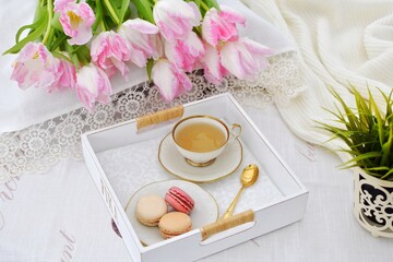 Morning tea with cookies on a tray and pink tulips.