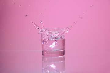 ice cubes falling into glass of water