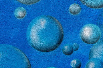 urban street wall aerosol graffiti painting with drawing of colorful round bubbles and balls in...