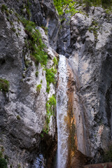 Fototapeta na wymiar turquoise crystal clear water of a waterfall of a mountain Alpine river