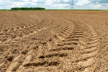 Traces de roues de tracteur dans la terre dans un champ