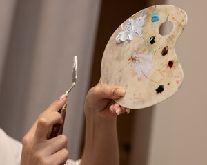 Teacher shows how to mix the paint on the palette with a palette knife