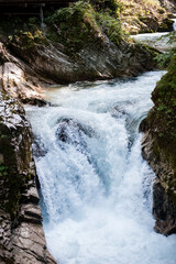 turquoise crystal clear water of a waterfall of a mountain Alpine river