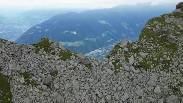 Flight over col Hochgangscharte towards valley with village Partschins and mountain panorama in Texel group, South Tyrol, Italy