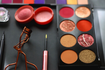 Various colorful make up products on dark background. Selective focus.